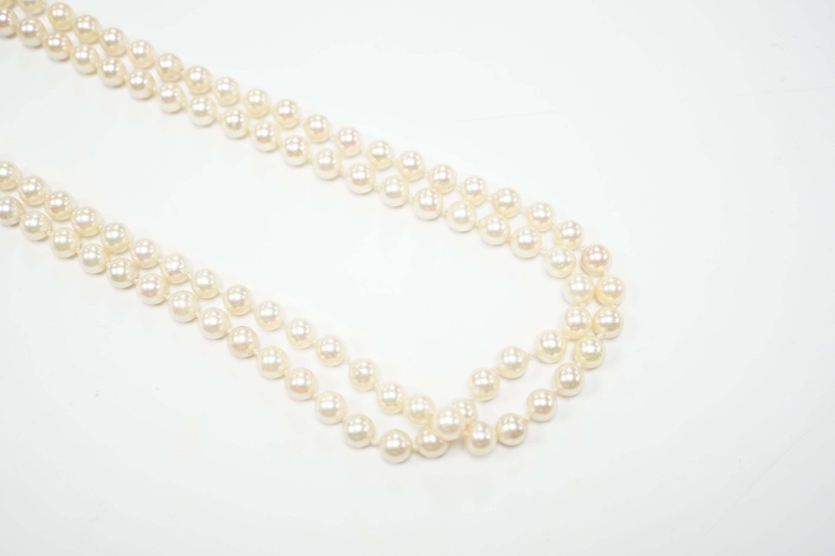 A Portuguese single strand cultured pearl necklace, with cabochon nephrite and seed pearl cluster set yellow metal clasp, 86cm.